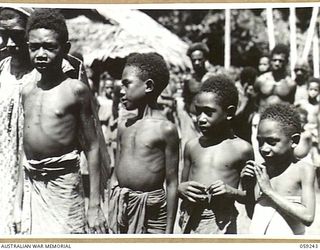 WIDERU, NEW GUINEA, 1943-10-21. TYPICAL WIDERU NATIVES WAITING TO BE QUESTIONED BY NX155085 CAPTAIN R.G. ORMSBY OF THE AUSTRALIAN AND NEW GUINEA ADMINISTRATIVE UNIT