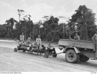 TADJI NEAR AITAPE, NORTH EAST NEW GUINEA. C. 1944-10. BOMBS BEING HAULED ON A TRAILER BEHIND A TRUCK TO AIRCRAFT OF NO. 8 (BEAUFORT) SQUADRON RAAF. THIS SQUADRON HOLDS THE WORLD RECORD FOR ONE DAYS ..