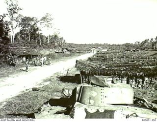 NEW IRELAND, 1945-10. WELL STOCKED JAPANESE SUPPLY AREA UNDERGOING INSPECTION BY ALLIED AND JAPANESE SERVICE PERSONNEL. (RNZAF OFFICIAL PHOTOGRAPH.)