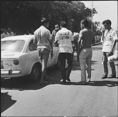 Spectators and crew observing a rally car during the 1st Safari Calédonien racing event, New Caledonia, 1967, 2 / Michael Terry