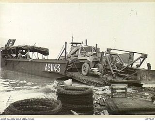 JACQUINOT BAY, NEW BRITAIN. 1944-12-16. PERSONNEL OF THE 2/3RD RAILWAY CONSTRUCTION COMPANY UNLOADING HEAVY EARTH MOVING EQUIPMENT FROM THE LANDING BARGE, AB1143. IDENTIFIED PERSONNEL ARE:- QX13969 ..