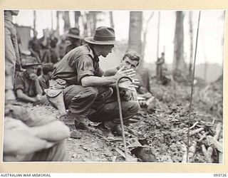 WEWAK AREA, NEW GUINEA, 1945-06-29. MAJ-GEN J.E.S. STEVENS, GOC 6 DIVISION (1) DURING A VISIT OF INSPECTION TO MOUNT SHIBURANGU, SPEAKING WITH CAPT M.J. DWYER COMMANDING OFFICER C COMPANY, 2/8 ..