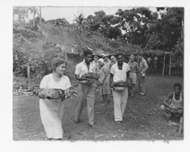 [South Pacific Natives Carry Food]