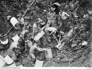 GUY'S POST - MAIN STREAM ROAD, DUMPU AREA, NEW GUINEA. 1944-04-16. MEMBERS OF THE 15TH FIELD COMPANY, ROYAL AUSTRALIAN ENGINEERS BUILDING AN 18 INCH ARMCO CULVERT ON A SECTION OF THE NEW ROAD. THE ..