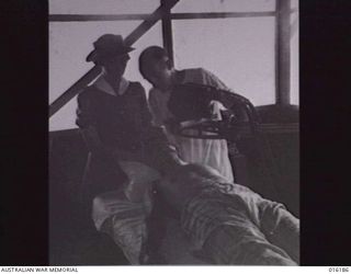 NEW GUINEA. 1943-11-22. AT AN AUSTRALIAN FIELD HOSPITAL TROOPER R.E. SCOTT OF BALLARAT, VIC. HAS X.RAY THERAPY TREATMENT AT THE HOSPITAL. WITH HIM ARE SISTER E. PATRICK AND PRIVATE L. FULLER