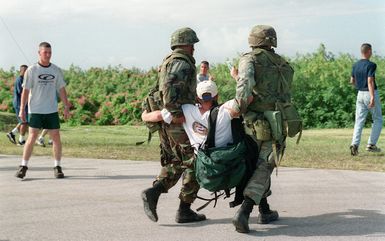 US Army (USA) Soldiers assigned to A/Company, 1ST Battalion, 17th Infantry Division remove a protester during a mock demonstration, while practicing riot control techniques, part of the Non-combatant Evacuation Operations (NEO) at Orote Point, Guam, conducted during Exercise TANDEM THRUST '99