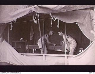 SEVENTEEN MILE, NEW GUINEA. 1943-09-23. MEMBERS OF THE 2/1ST AUSTRALIAN ARMY TOPOGRAPHICAL SURVEY COMPANY, WORKING ON A PROOFING PRESS. NX87330 SAPPER (SPR) R. L. ROWLEY (LEFT); QX55369 SPR W. J. ..