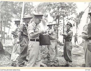 MALMAL VILLAGE, NEW BRITAIN. 1944-11-28. AUSTRALIAN ARMY OFFICERS DISCUSSING OPERATIONS IN THE AREA OUTSIDE THE OFFICER'S MESS OF R.A. WITNEY (1); VX9767 LIEUTENANT-COLONEL A.J. MCLEAN (2); VX63919 ..