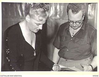 LAE AREA, NEW GUINEA. 1945-08-18. GRACIE FIELDS (1) AND HER ACCOMPANIST, ERIC FOX (2), SELECTING HER SONGS FOR THE CONCERT AT THE LAE BASE THEATRE