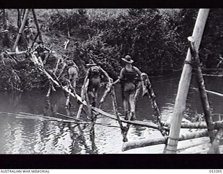 SOGERI VALLEY, NEW GUINEA. 1943-06-29. "V" FRAME SUSPENSION BRIDGE CONSTRUCTED BY THE PIONEER PLATOON, 9TH INFANTRY BATTALION, IN FOUR HOURS, FROM MATERIAL ON SITE. TROOPS OF THE 9TH INFANTRY ..