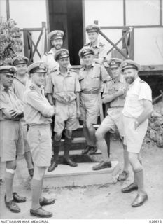 PORT MORESBY, PAPUA. 1942-09. COMMANDER R.B.A. HUNT RAN (EXTREME RIGHT), NAVAL OFFICER IN COMMAND AT PORT MORESBY, AND HIS STAFF ON THE STEPS OF THEIR QUARTERS