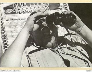 PAPUA, NEW GUINEA. 1942-08. AN ARMCHAIR JOB: AN AMERICAN AIRMAN KEEPS A LOOK-OUT FOR ENEMY PLANES