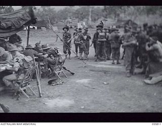 NEW GUINEA. 1943-08-20. GENERAL VIEW OF THE ELECTION VOTING FACILITIES FOR THE 2/16TH BATTALION. SHOWN ARE:- NX59202 STAFF SERGEANT W. HADDON (1); QX29354 PRIVATE (PTE) J. R. SPILLER (2); NX127103 ..