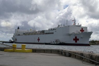 A starboard bow view of the US Navy (USN) Military Sealift Command (MSC), Hospital Ship, USNS MERCY (T-AH 19), being assisted by tugboats, while underway transiting the harbor at Apra Harbor, Naval Station Guam, after arriving for a one-day stop to give the crew a break and pick up Sailors assigned to Naval Mobile Construction Battalion 40 (NMCB-40). The USNS MERCY is currently conducting a scheduled five-month deployment to deliver aid and humanitarian assistance to the Pacific Islands and Southeast Asia