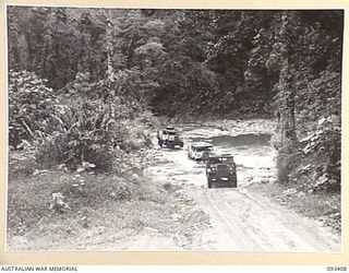 BARGES HILL, CENTRAL BOUGAINVILLE. 1945-06-27. VEHICLES OF 4 FIELD REGIMENT CROSSING THE EAST DOIABI RIVER ON THE NUMA NUMA TRAIL