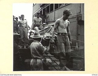 ORO BAY, NEW GUINEA. 1943-07. TROOPS OF THE 10TH FIELD AMBULANCE CARRYING A PATIENT FROM THE USS "KARU MARU" TO AN AMBULANCE FOR TRANSPORT TO THE UNIT MAIN DRESSING STATION