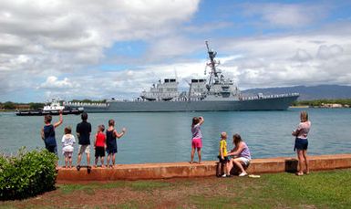 Family members at Hickam Air Force Base (AFB) welcome the Arleigh Burke Class Guided Missile Destroyer USS JOHN PAUL JONES (DDG 53) as the ship transits the channel into Pearl Harbor, Hawaii. JOHN PAUL JONES is visiting Pearl Harbor to take part in Rim of the Pacific (RIMPAC) 2004. RIMPAC is the largest international maritime exercise in the waters around the Hawaiian Islands. This years exercise includes seven participating nations: Australia, Canada, Chile, Japan, South Korea, the United Kingdom and the United States. RIMPAC enhances the tactical proficiency of participating units in a wide array of combined operations at sea, while enhancing stability in the Pacific Rim region