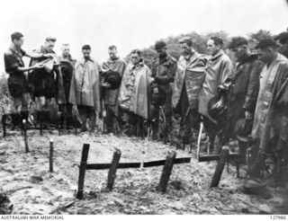Burial service for three Non commissioned Officer's (NCO's) of 2/3rd Australian Independent Company conducted by Father English (second from left), whose prayer book his batman, V155619 Private ..