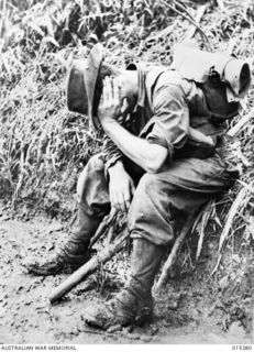 1943-08-03. NEW GUINEA. VX13245 PRIVATE. HERBERT GEORGE ESCREET, OF CARRAJUNG, VIC, RESTING DURING A HALT ON A TRACK IN THE MUBO AREA. (NEGATIVE BY G. SHORT)
