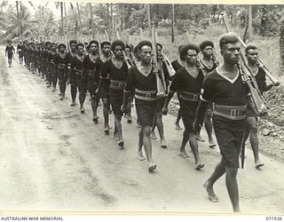 MILNE BAY, PAPUA, NEW GUINEA. 1944-04-01. MEMBERS OF THE ROYAL PAPUAN CONSTABULARY IN THE SAMARAI DISTRICT MARCHING WITH RIFLES AT THE SLOPE DURING A PARADE