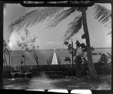 Tropique Hotel, Tahiti, showing man looking out at men walking on bridge