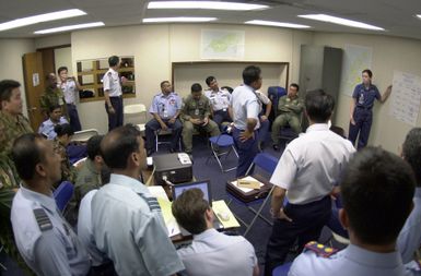 FLGOFF (Flying Officer) Melissa Dalby, 86th Wing (WG), Royal Australian Air Force, presents data for a new scenario to the squadron leaders of different countries during PACIFIC AIRLIFT RALLY 2001. PACIFIC AIRLIFT RALLY (PAR) is a PACAF-sponsored military airlift symposium for countries in the pacific region. PAR is held every two years and is hosted by a pacific nation. This year Andersen AFB, Guam is the host nation. The symposium includes informational seminars with area of expertise briefings, a command post exercise (CPX) which addresses military airlift support to a humanitarian airlift/disaster relief scenario, and a concurrent flying training program that builds upon the CPX scenario