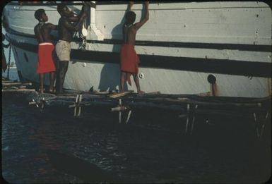 Selling pineapples from a canoe, unloading the cargo : New Britain coastline, Papua New Guinea, 1960 / Terence and Margaret Spencer