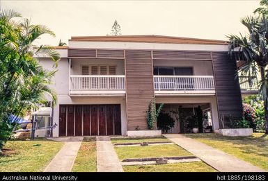 New Caledonia - wood and concrete building with white balcony railings