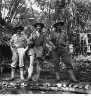 NEW GUINEA, 1943-07-27. V504081 WARRANT OFFICER E. BRITTEN (LEFT), DAMIEN PARER, WAR PHOTOGRAPHER (CENTRE) AND NG2022 SERGEANT A.M. GRAHAM (RIGHT). (CROPPED VERSION AT 044147)