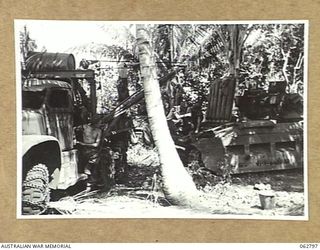 HUON PENINSULA AREA, NEW GUINEA. 1944-01-08. PERSONNEL OF THE 209TH LIGHT AID DETACHMENT REMOVING A GEARBOX FROM A MATILDA TANK WITH THEIR MOBILE CRANE IN THE UNIT WORKSHOP AREA ON THE BANK OF THE ..