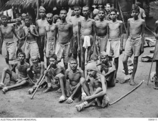 KUMUIA YAMA, RABAUL AREA, NEW BRITAIN. 1945-09-17. A GROUP OF INDIAN TROOPS AT THE INDIAN PRISONER OF WAR CAMP. THEY REFLECT THE ILL TREATMENT METED OUT BY THE JAPANESE. SOME ARE TOO WEAK TO STAND. ..