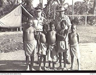 LAE, NEW GUINEA. 1944-09-18. TX2002 BRIGADIER J. FIELD DSO ED, COMMANDING 7TH INFANTRY BRIGADE (1) AND VX48010 MAJOR J. SUMMERTON (2) WITH FIVE NATIVE CHILDREN WHO LED BRIGADIER FIELD AND HIS PARTY ..