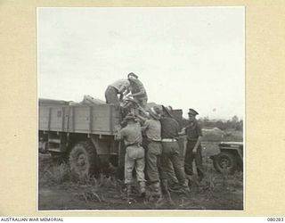 NADZAB, NEW GUINEA. 1944-10-21. MEMBERS OF HEADQUARTERS NEW GUINEA FORCE GATHER PARACHUTE CONTAINERS FOLLOWING TESTS DETERMINING THE EFFECTIVENESS OF HESSIAN PARACHUTES AND STORPEDO CONTAINERS. ..