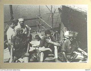 PORT MORESBY, NEW GUINEA. 1942-04-12. EVACUEES FROM NEW BRITAIN RELAXING ON THE DECK OF THE HMAS "LAURABADA" AS THE SHIP DRAWS INTO THE WHARF. THESE EVACUEES, SERVICE PERSONNEL AND CIVILIANS, TOOK ..