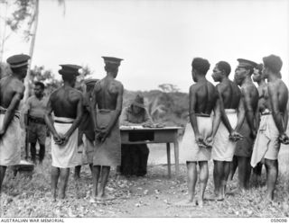 BUKAUA, NEW GUINEA. 1943-10-18. NX155085 CAPTAIN R. G. ORMSBY OF THE AUSTRALIAN AND NEW GUINEA ADMINISTRATION UNIT TALKING TO THE NATIVE VILLAGERS