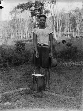 [Portrait of Pacific Island man holding a bucket]