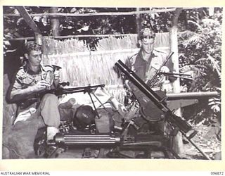 LAKANUI, NEW BRITAIN. 1945-09-15. PRIVATE T.C. VANDERWOLF (1) AND CORPORAL D. MACKIESON (3), GUARDING A VICKERS MK 1, TWO JAPANESE 7.7MM TYPE 99 AND ONE TYPE 92 (LEWIS) MACHINE GUNS AT AN ..