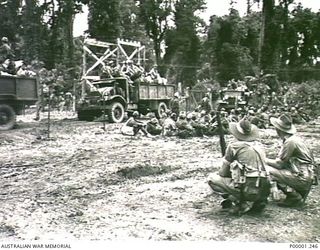THE SOLOMON ISLANDS, 1945-09-19. ALLIED TRUCKS LOADED WITH THE PERSONAL EFFECTS OF JAPANESE TROOPS FROM NAURU ISLAND ARRIVING AT THE INTERNMENT CAMP ON BOUGAINVILLE ISLAND TO WHICH THE JAPANESE HAD ..