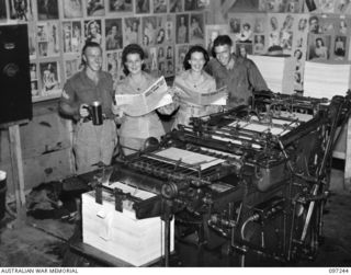 LAE, NEW GUINEA. 1945-09-05. PRIVATE W. JACKSON AND SERGEANT W.J. DORRELL SHOWING TWO AUSTRALIAN WOMEN'S ARMY SERVICE GUESTS THE MILLER PRESS WHICH IS USED TO PRODUCE THE ARMY NEWSPAPER GUINEA ..