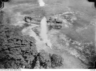 WAK, NEW GUINEA. 1944-03-19. JAPANESE SHIP RUN ASHORE AFTER A DIRECT HIT IN A RAID ON SHIPPING OFF MUSCHU ISLAND, BY BOMBERS OF FIFTH AIR FORCE, UNITED STATES ARMY AIR FORCE