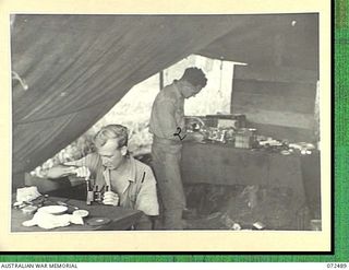 DUMPU, NEW GUINEA. 1944-04-20. Q122394 CRAFTSMAN S. NUTTALL, INSTRUMENT MECHANIC (1), WITH QX59075 CRAFTSMAN E.O. OSS, RADIO MECHANIC (2), WORKING IN THE INSTRUMENT AND RADIO REPAIR SHOP OF THE ..