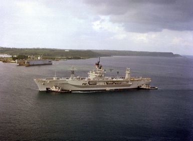 Large harbor tugs maneuver the amphibious command ship USS BLUE RIDGE (LCC-19) into the harbor