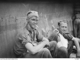 WAITAVALO AREA, WIDE BAY, NEW BRITAIN. 1945-03-16. PRIVATE H.J. ADAMS (1), AND VX39213 LIEUTENANT A.G. MAWSON, AWAIT EVACUATION BY LCM (LANDING CRAFT MECHANIZED) WITH OTHER MEMBERS OF THE 14/32ND ..