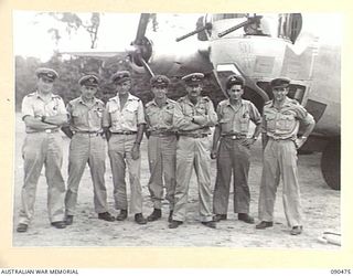 TOROKINA, BOUGAINVILLE. 1945-04-11. SQUADRON LDR J. O'BRIEN, RAAF (1), AND HIS CREW STANDING BEFORE THEIR LIBERATOR WHICH TOOK SENATOR J. M. FRASER, ACTING MINISTER FOR THE ARMY, AND PARTY, BACK TO ..