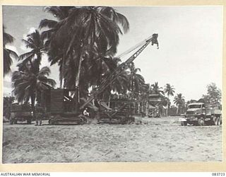 AITAPE, NEW GUINEA. 1944-11-22. EQUIPMENT ON THE BEACH PROVIDES ASSISTANCE WITH THE SUPPLY FLOW TO AUSTRALIAN AND US FORCES. THE PICTURE INCLUDES A CRANE, COMPRESSOR, BULLDOZER AND CATERPILLAR ..