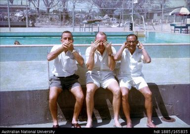 Three men posing as the three wise monkeys