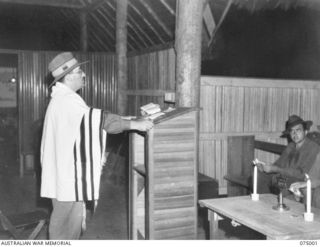 VX354 Chaplain L M Goldman (standing) conducting a Jewish religious service in the United States Army Jewish chapel