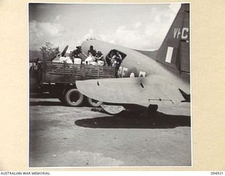 WEWAK AIRSTRIP, NEW GUINEA. 1945-08-06. KAI BOMBERS BEING LOADED BY HEADQUARTERS COMMAND, AUSTRALIAN ARMY SERVICE CORPS, 6 DIVISION. UNITS IN REMOTE FORWARD AREAS ARE SUPPLIED BY PARACHUTE DROPS ..