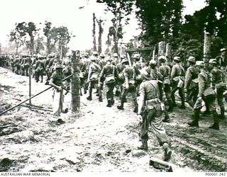 THE SOLOMON ISLANDS, 1949-09-19. JAPANESE TROOPS FROM NAURU ISLAND, UNDER AUSTRALIAN GUARDS, ENTERING THE GATES OF AN INTERNMENT CAMP ON BOUGAINVILLE ISLAND AFTER MARCHING FROM TOROKINA, (RNZAF ..