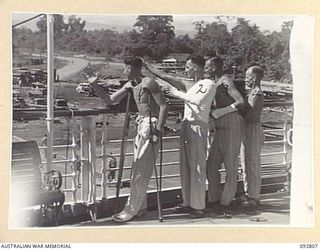 LAE, NEW GUINEA. 1945-06-09. PATIENTS FROM 2/7 GENERAL HOSPITAL ON BOARD THE HOSPITAL SHIP MANUNDA AT MILFORD HAVEN, WAVE GOODBYE TO NEW GUINEA ON THEIR WAY SOUTH. IDENTIFIED PERSONNEL ARE:- ..